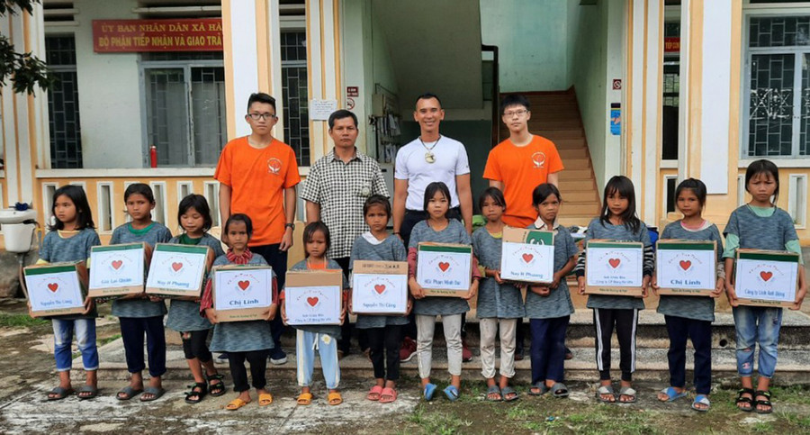 Trọng tài Nguyên Thành (hàng đứng, thứ 2 từ phải sang) trao quà cho học sinh nghèo xã Hà Đông (huyện Đak Đoa). Ảnh: Phương Duyên
