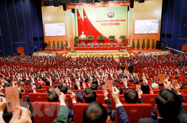 Các đại biểu biểu quyết, thông qua Nghị quyết Đại hội XIII Đảng Cộng sản Việt Nam. (Ảnh: TTXVN)