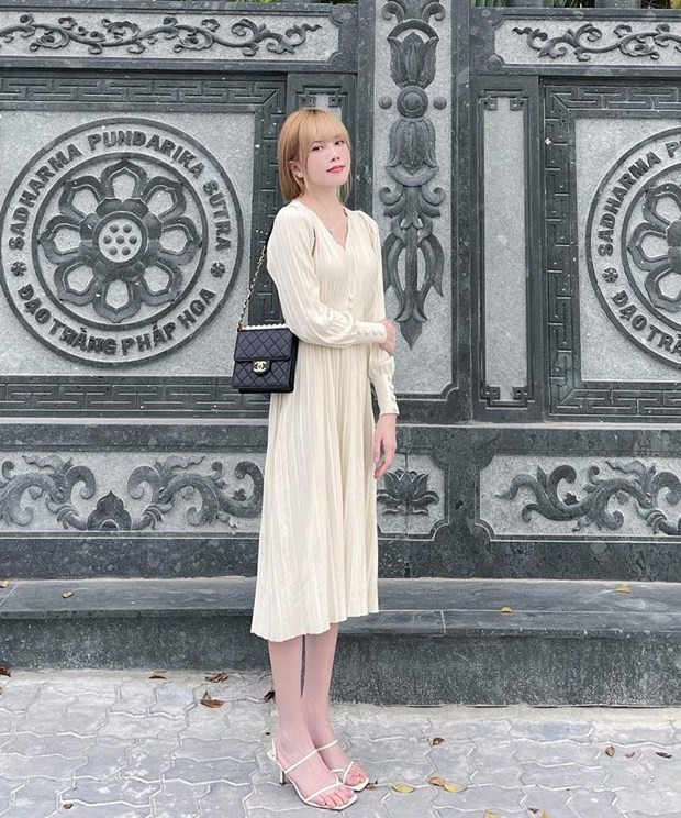  Đầm trắng thắt eo và sandals tiệp màu, điểm túi Chanel nhỏ, giúp Thiều Bảo Trâm làm bật vẻ dịu dàng.