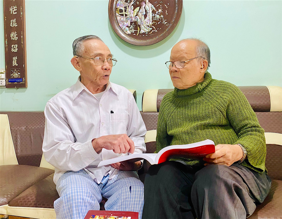 Ông Nguyễn Quốc Thành (bìa phải; phường Tây Sơn, thị xã An Khê) nhắc nhớ về quá trình điền dã tìm hiểu việc chuẩn bị khởi nghĩa của anh em nhà Tây Sơn trên đất An Khê xưa. Ảnh: Hồng Thi