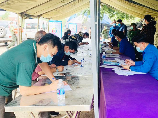 Người từ Gia Lai (bìa trái) về Bình Định thực hiện khai báo y tế tại chốt kiểm tra phòng chống dịch ở H.Vĩnh Thạnh (Bình Định) ẢNH: THANH MAI