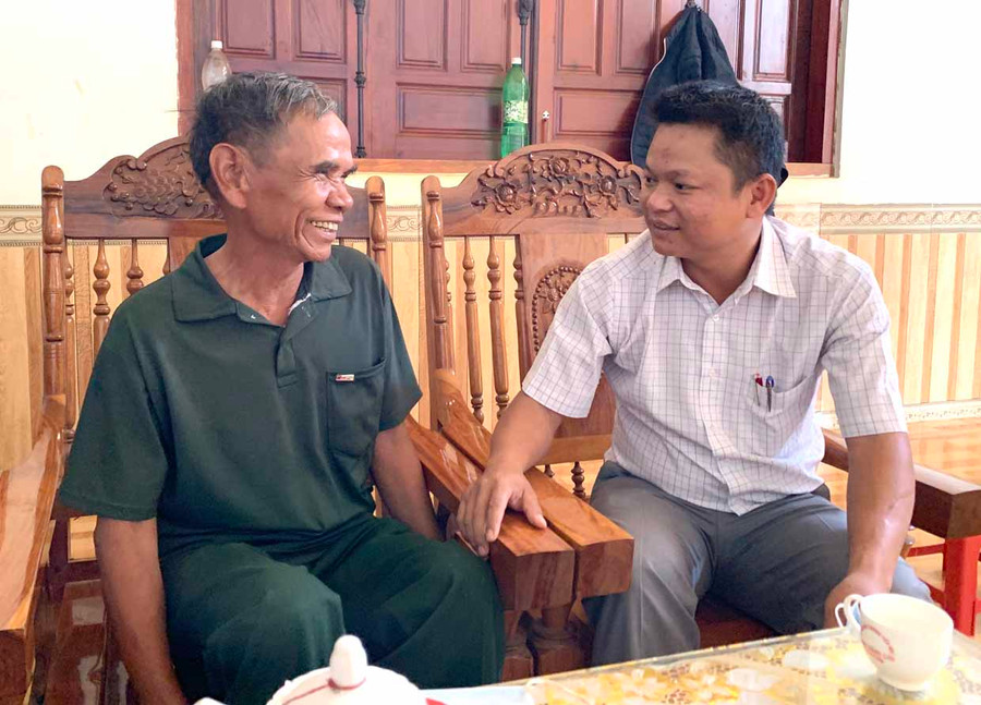 Già làng Siu Kim (bìa trái) trao đổi với lãnh đạo xã Ia Púch về việc vận động dân làng phát triển sản xuất. Ảnh: Hà Duy