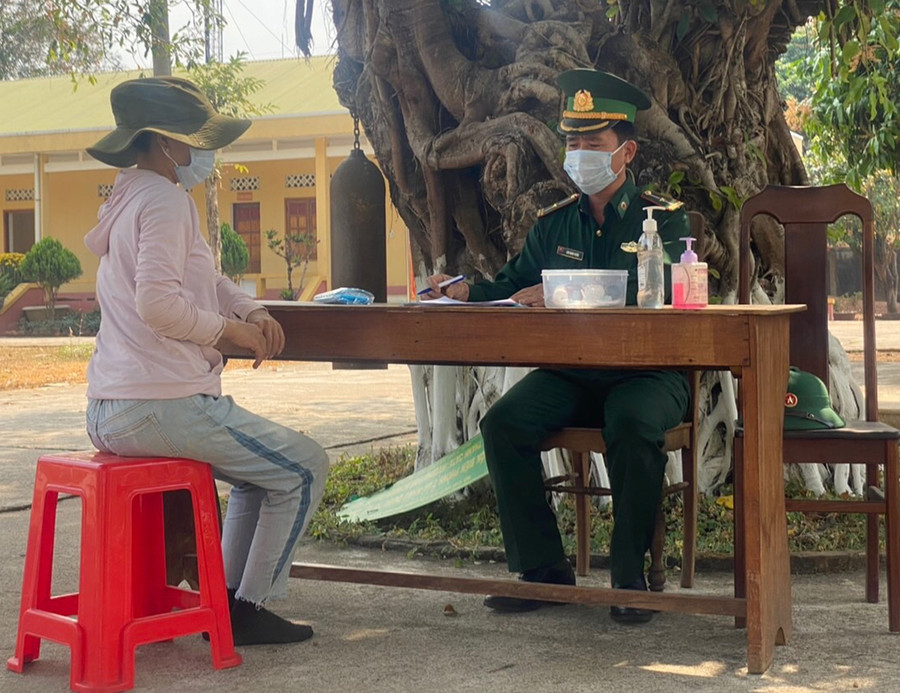 Thiếu tá Lâm Mạnh Tuyển đang hướng dẫn người dân khai báo y tế. Ảnh: Anh Huy