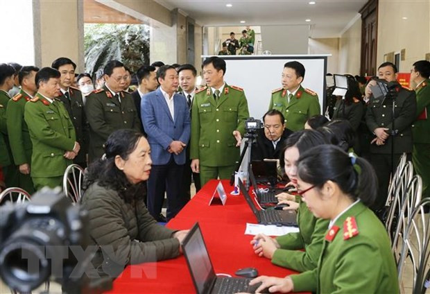 Thiếu tướng Nguyễn Duy Ngọc, Thứ trưởng Bộ Công an và các đại biểu thăm quan việc triển khai của các đơn vị công an quận cấp Căn cước công dân lưu động. (Ảnh: Doãn Tấn/TTXVN)