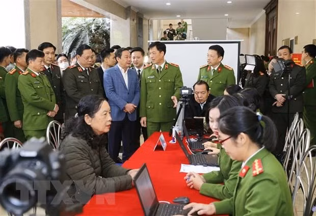 Thiếu tướng Nguyễn Duy Ngọc, Thứ trưởng Bộ Công an và các đại biểu thăm quan việc triển khai của các đơn vị công an quận cấp Căn cước công dân lưu động. (Ảnh: Doãn Tấn/TTXVN)