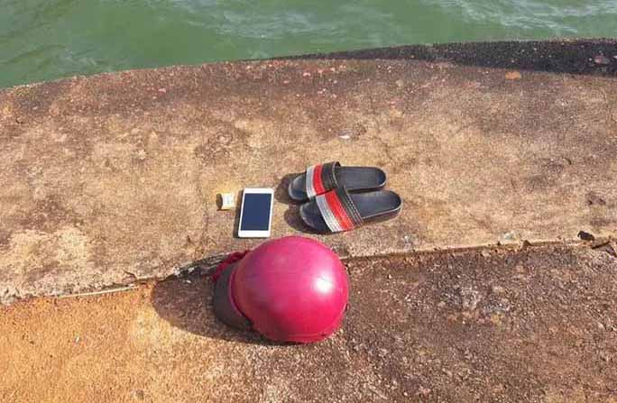 Điện thoại, mũ bảo hiểm và đôi dép của chị N trên bờ