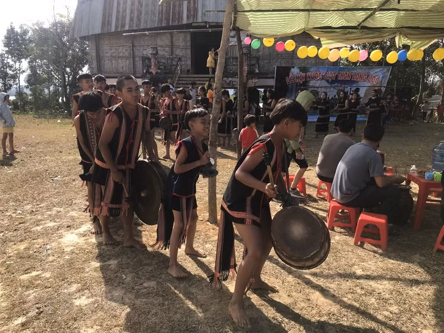 Các em nhỏ trong bộ trang phục thổ cẩm chơi cồng chiêng tại Lễ hội. (Ảnh: Khoa Chương/TTXVN)