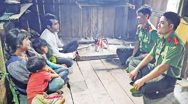 Gia đình Kưnh trò chuyện với cán bộ an ninh Công an huyện Mang Yang. Ảnh: Thúy Trinh