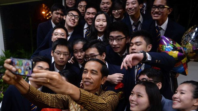 Tổng thống Joko Widodo chụp ảnh với bạn cùng lớp của con trai tại Singapore - Ảnh: AFP  Tổng thống Joko Widodo chụp ảnh với bạn cùng lớp của con trai tại Singapore - Ảnh: AFP