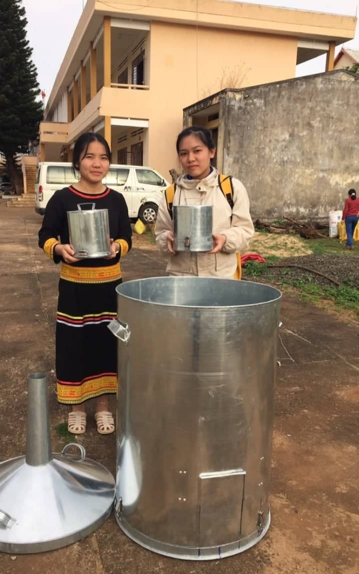 Em Hà Thị Mai Lan và Ngân Thị Ngọc Mai (học sinh lớp 12A, Trường PTDTNT tỉnh) kiểm tra lò đốt yếm khí biochar. Ảnh: Hoàng Minh