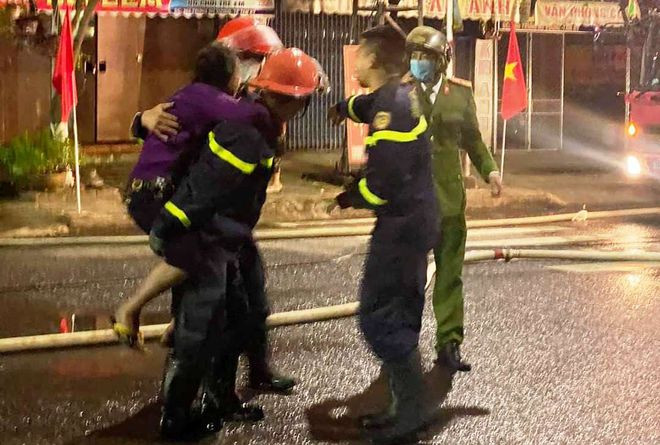 Phá cửa cứu 6 người mắc kẹt trong vụ cháy nhà ngày mùng 4 tết ảnh 2 Lực lượng cứu hộ phá cửa cứu cụ bà 81 tuổi ra khỏi đám cháy.