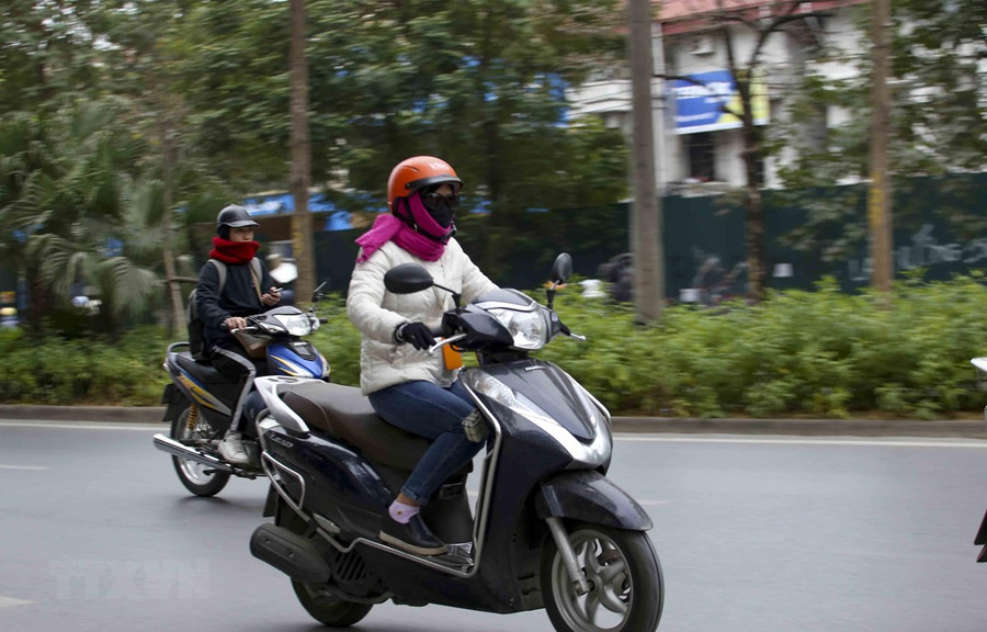 Người dân khi ra đường nên mặc ấm, đeo khẩu trang và mang theo áo mưa đề phòng những cơn mưa. (Ảnh: Tuấn Đức/TTXVN) Người dân khi ra đường nên mặc ấm, đeo khẩu trang và mang theo áo mưa đề phòng những cơn mưa. (Ảnh: Tuấn Đức/TTXVN)
