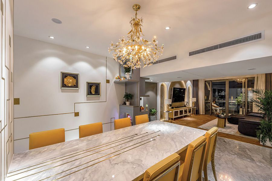 Khu vực bàn ăn được tạo điểm nhấn bằng bộ đèn chùm. Mặt bàn sử dụng chất liệu đá. Hầu hết các bề mặt như tường, mặt bàn, mặt tủ đều có những chi tiết trang trí sinh động.