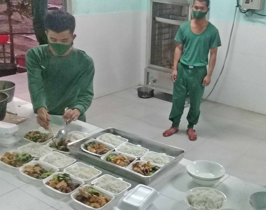 cán bộ, chiến sĩ ở khu cách ly tập trung thao trường Jít Tú đang chuẩn bị phần ăn cho người cách ly