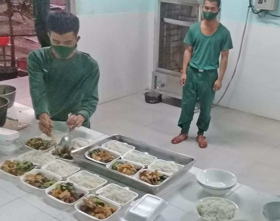 cán bộ, chiến sĩ ở khu cách ly tập trung thao trường Jít Tú đang chuẩn bị phần ăn cho người cách ly