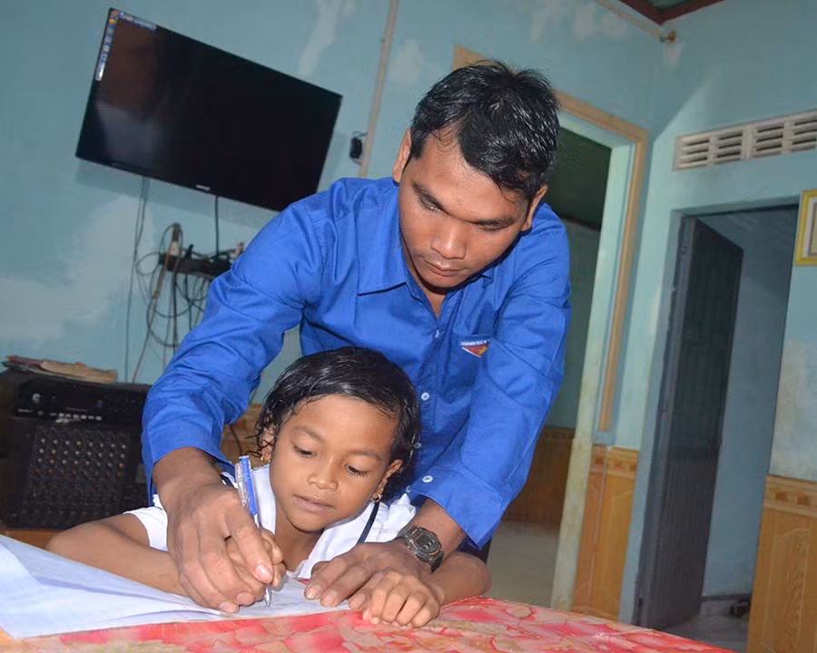  Rơ Mah Thinh chăm chút cho con từng nét chữ. Ảnh: L.L