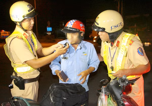 Cán bộ Đội Cảnh sát giao thông Đa Phước (PC67 - Công an TPHCM) kiểm tra nồng độ cồn của một người điều khiển phương tiện lưu thông trên quốc lộ 50, huyện Bình Chánh.