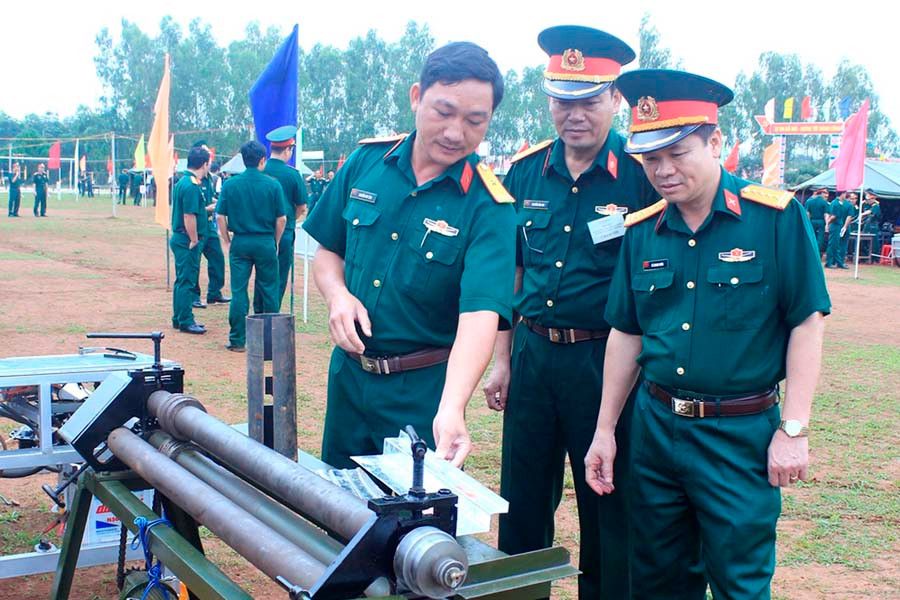 Thiếu tá Nguyễn Duy Tân (thứ 3 từ phải sang) đang giới thiệu sáng kiến “Máy uốn ép tôn đa năng”. Ảnh: V.D.H  Thiếu tá Nguyễn Duy Tân (thứ 3 từ phải sang) đang giới thiệu sáng kiến “Máy uốn ép tôn đa năng”. Ảnh: V.D.H