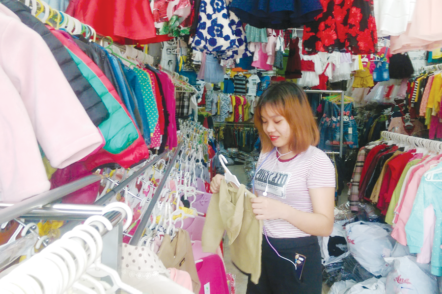 Chọn mua hàng tại một shop quần áo trẻ em. Ảnh: L.L Chọn mua hàng tại một shop quần áo trẻ em. Ảnh: L.L