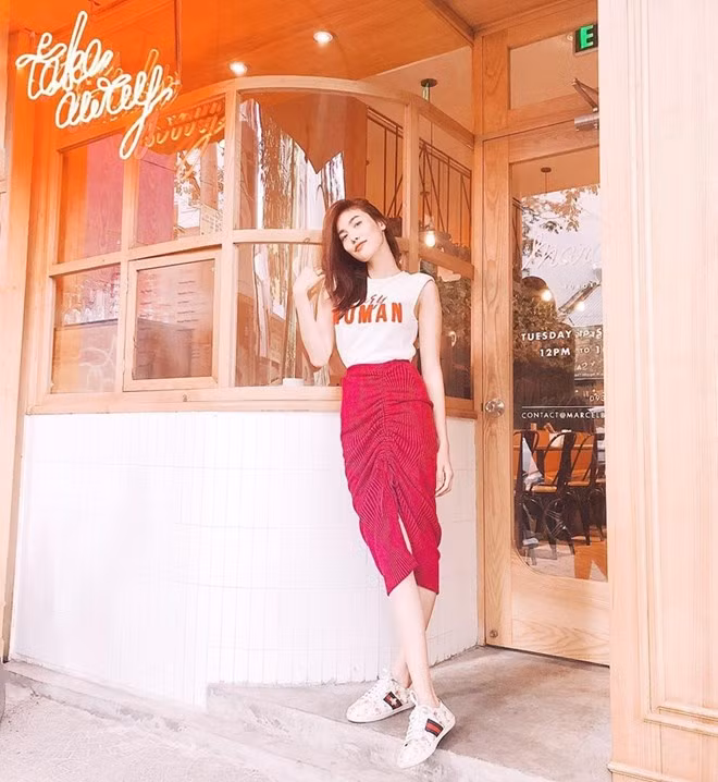  Lan Khuê mix ăn ý áo thun trắng in chữ với chân váy xẻ tà, mang giày sneakers Ace của Gucci càng làm nổi bật vẻ ngoài khoẻ khoắn.