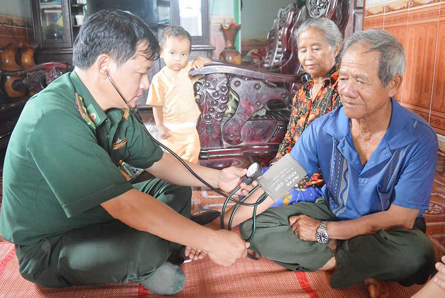  Thiếu tá Trần Văn Dũng đang chăm sóc sức khỏe cho ông Siu Thiu. Ảnh: A.H