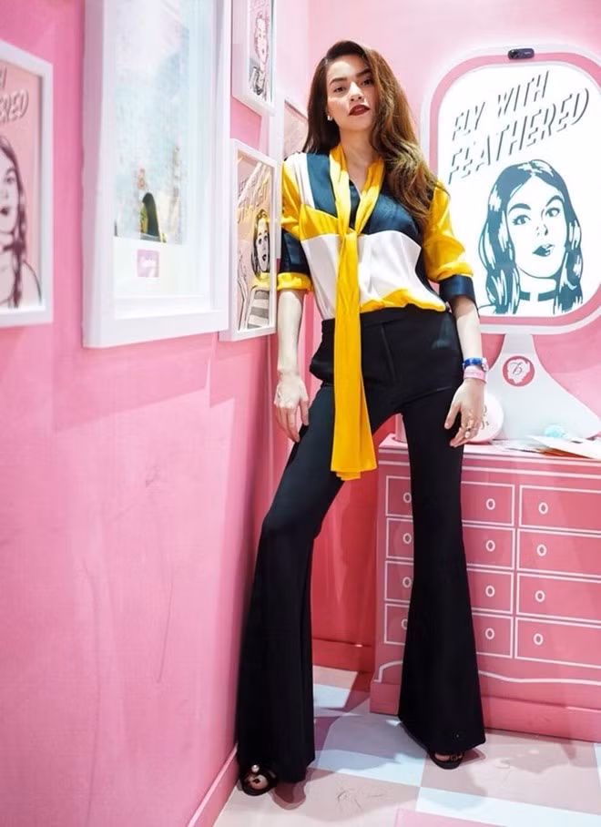  Hồ Ngọc Hà khoe khéo chiều cao lý tưởng bằng cách sơ vin áo blouse đa sắc với quần ống loe. Bộ cánh đơn giản song làm nổi bật được tinh thần ''Girl Boss'', giúp người đẹp tô đậm cùng lúc vẻ thanh lịch song cũng đầy sức quyến rũ, mạnh mẽ.