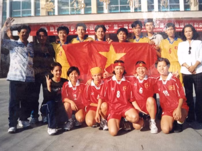 Huyền Trang (số 10) chụp kỷ niệm cùng các đồng đội bên cạnh quốc kỳ Việt Nam trước thềm giải đá cầu tại Trung Quốc.