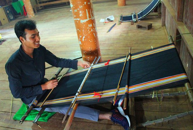 Y Dhông ngồi dệt bên khung cửi. Ảnh: N.T