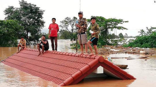Nhiều nạn nhân phải leo lên mái nhà để tránh nước lũ. Ảnh: CNN Nhiều nạn nhân phải leo lên mái nhà để tránh nước lũ. Ảnh: CNN