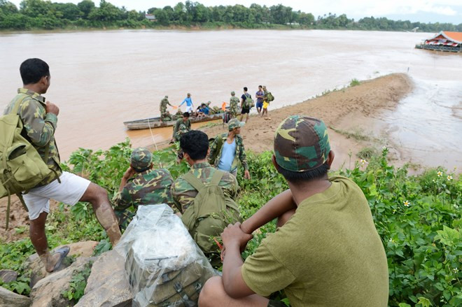 Binh sỹ Lào hỗ trợ người dân sơ tán khỏi vùng nguy hiểm ở Attapeu. Binh sỹ Lào hỗ trợ người dân sơ tán khỏi vùng nguy hiểm ở Attapeu.