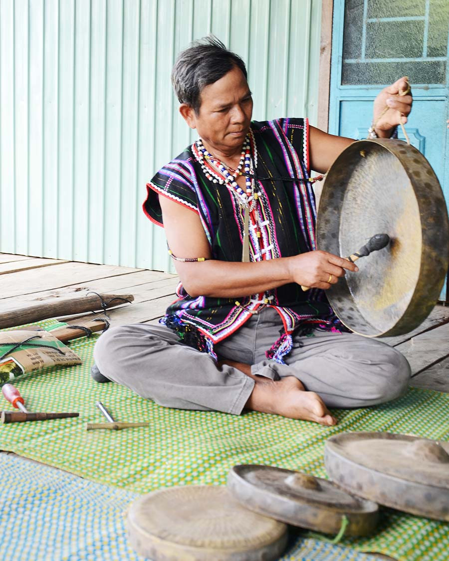Ông Đinh Keo đang chỉnh lại âm thanh cho bộ chiêng bị lạc giọng. Ảnh: P.L