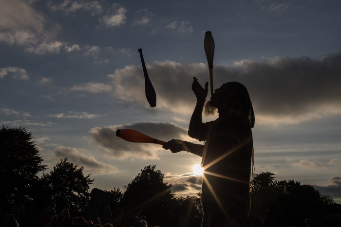 Trong khi đó, người đàn ông này còn tung hứng diễn xiếc trong lúc đợi đón bình minh - Ảnh: Matt Cardy/Getty Images
