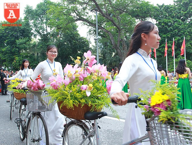 Vẻ đẹp của tà áo dài tôn thêm nét duyên dáng, thanh lịch đầy nữ tính của người phụ nữ Hà Nội bên những xe hoa  Vẻ đẹp của tà áo dài tôn thêm nét duyên dáng, thanh lịch đầy nữ tính của người phụ nữ Hà Nội bên những xe hoa