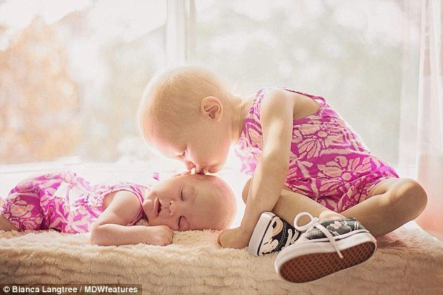 Cô bé anh hùng Harlow (bên trái) sau khi được chuẩn đoán mắc ung thư buồng trứng đang hôn em gái