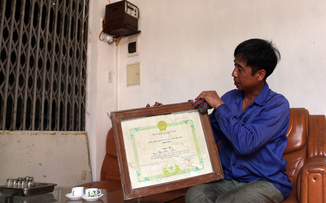 Ông Vũ Văn Nga lau khung Huân chương Chiến công hạng ba