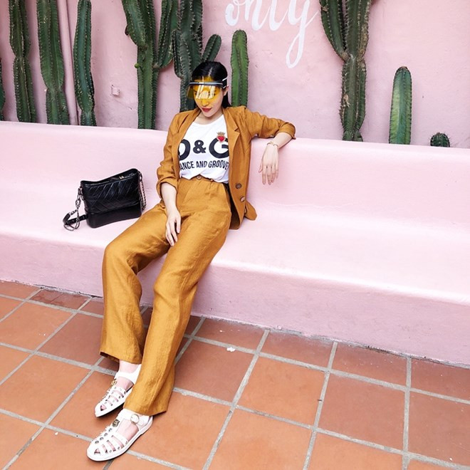  Kỳ Duyên kết hợp áo phông in chữ của Dolce & Gabbana với blazer và quần ống rộng màu cam, điểm trang bằng sandals Gucci, ''mũ kính'' Dior và túi xách Chanel đắt đỏ. Chỉ một bộ đồ dạo phố của Hoa hậu Việt Nam 2014 cũng đã có giá vượt ngưỡng 100 triệu đồng.