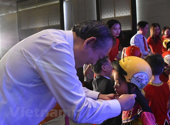 Phó Thủ tướng Chính phủ Trương Hòa Bình trao tặng mũ bảo hiểm cho học sinh lớp Một. 