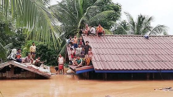 Người dân ngồi trên nóc nhà khi nước lũ dâng cao sau sự cố vỡ đập thủy điện. Ảnh: ABC News Laos