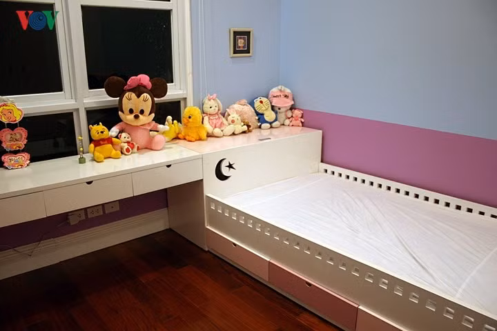  Giường, trong một số trường hợp không nhất thiết phải kê hở hai phía. Đây là giường đơn cho trẻ nên được kê áp vai về phía tường để tận dụng thêm mặt bằng. Phần phía dưới vai giường được thiết kế thành các ngăn kéo để đồ.