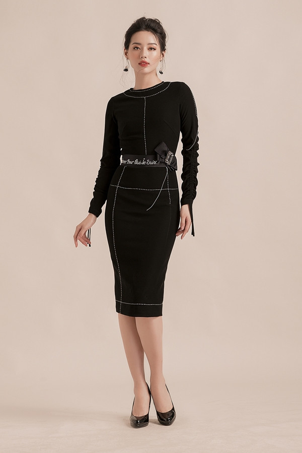 Thiết kế váy bút chì bớt nhàm chán và tăng thêm vẻ nữ tính nhờ thắt lưng đính nơ. Khánh Linh diện thêm giày cao gót mũi nhọn màu đen hoặc nude - hai tông màu cơ bản có thể dễ dàng phối cùng nhiều loại trang phục.