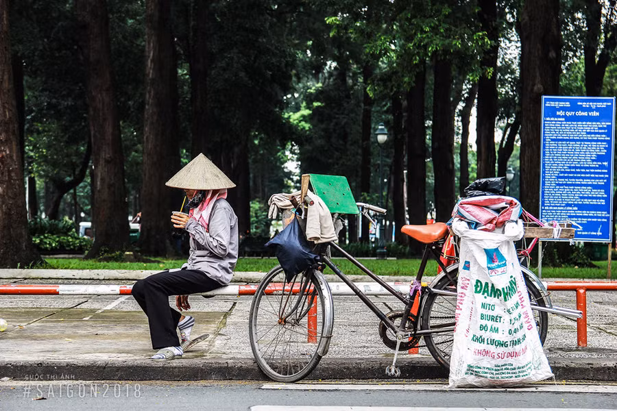 Cuộc sống mưu sinh vất vả khiến người phụ nữ chỉ có thể tranh thủ nghỉ trưa ngay bên đường trong ít phút. Ảnh: Trần Hoàng Vũ.