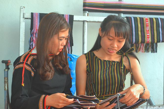  H’Sanh (bìa phải) giới thiệu các mẫu thổ cẩm.