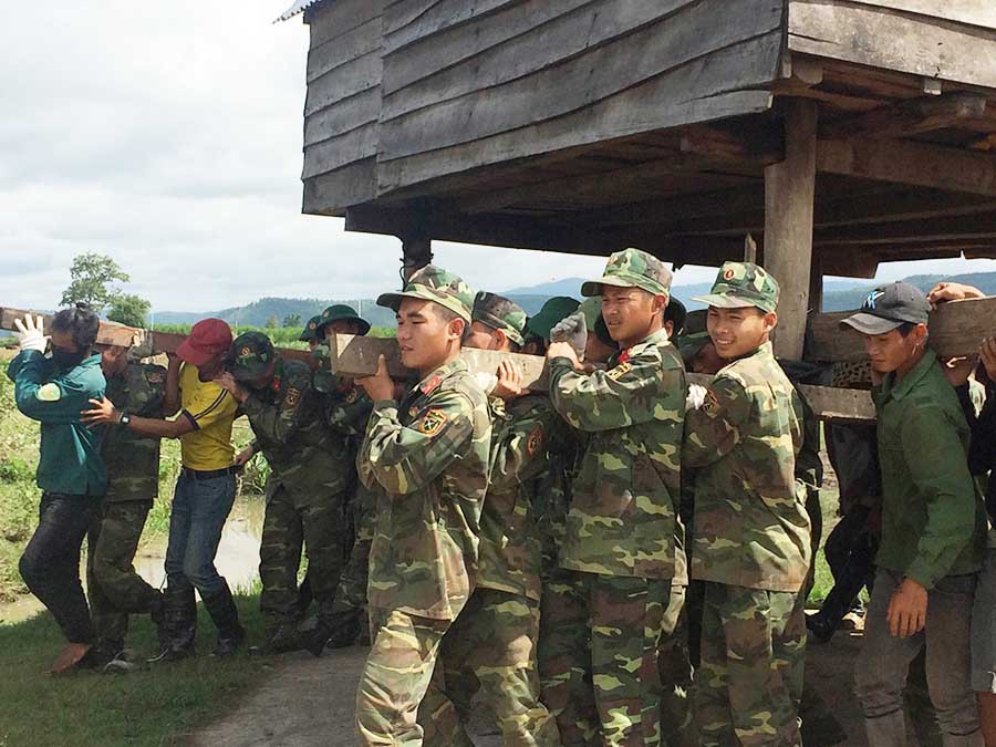  Các cán bộ chiến sĩ Tiểu Đoàn 21, Quân Đoàn 3 ra sức giúp bà con di dời nhà ở. Ảnh: Như Loan