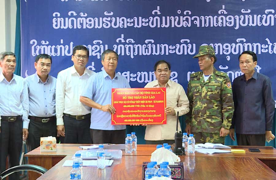 Ông Nguyễn Thành Nuôi trao 350 suất quà hỗ trợ nhân dân, cán bộ tỉnh Attapeu. Ảnh: Nguyễn Tú