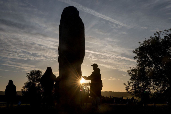Người dân tín ngưỡng chạm tay vào đá tại các di chỉ vòng tròn đá tại Wiltshire, Anh - Ảnh: Matt Cardy/Getty Images