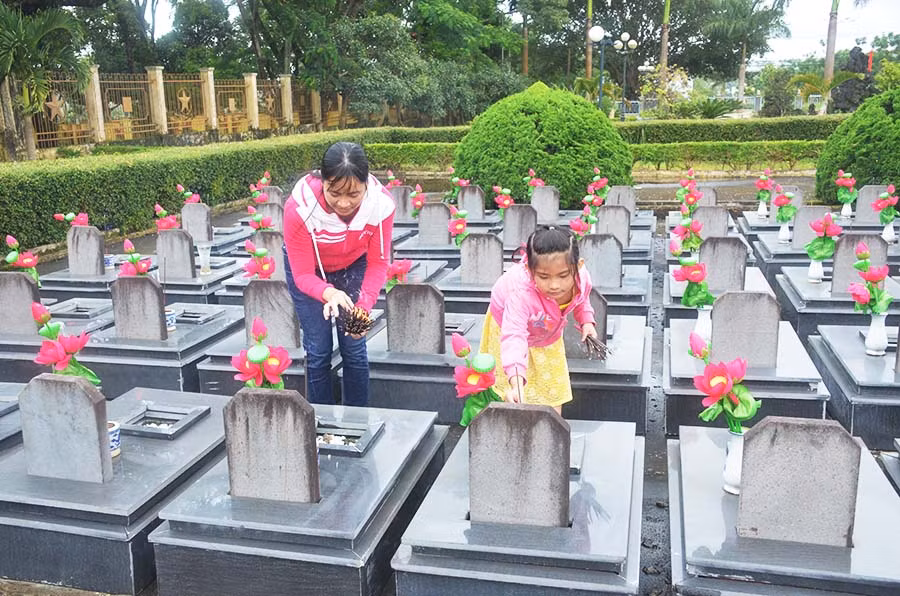  Chị Lê Phú Hà cùng con gái thắp hương tại Nghĩa trang Liệt sĩ tỉnh. Ảnh: V.H