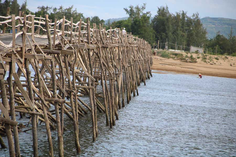 Mặt và trụ cầu được làm hoàn toàn từ ván gỗ, thành cầu nối với nhau bằng thân tre. 