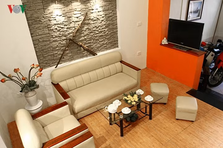  Không gian liên thông giữa nơi để xe phía ngoài và phòng khách. Bức tường lửng là ranh giới ước lệ cũng là nơi đặt tivi. 