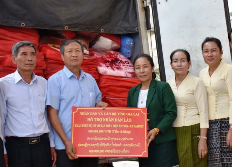 Tỉnh Gia Lai-đơn vị kết nghĩa với tỉnh Attapeu đã cử đoàn công tác sang thăm hỏi, chia sẻ và hỗ trợ 400 triệu đồng. Trong ảnh, ông Nguyễn Thành Nuôi-Phó Chủ tịch Ủy ban MTTQ Việt Nam tỉnh trao hàng hóa cứu trợ của Gia Lai cho lãnh đạo tỉnh Attapeu