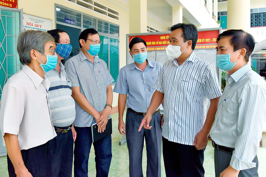 Các ứng cử viên đại biểu HĐND tỉnh khóa XII trao đổi với cử tri phường Hội Thương (TP. Pleiku) bên lề hội nghị. Ảnh: Đức Thụy